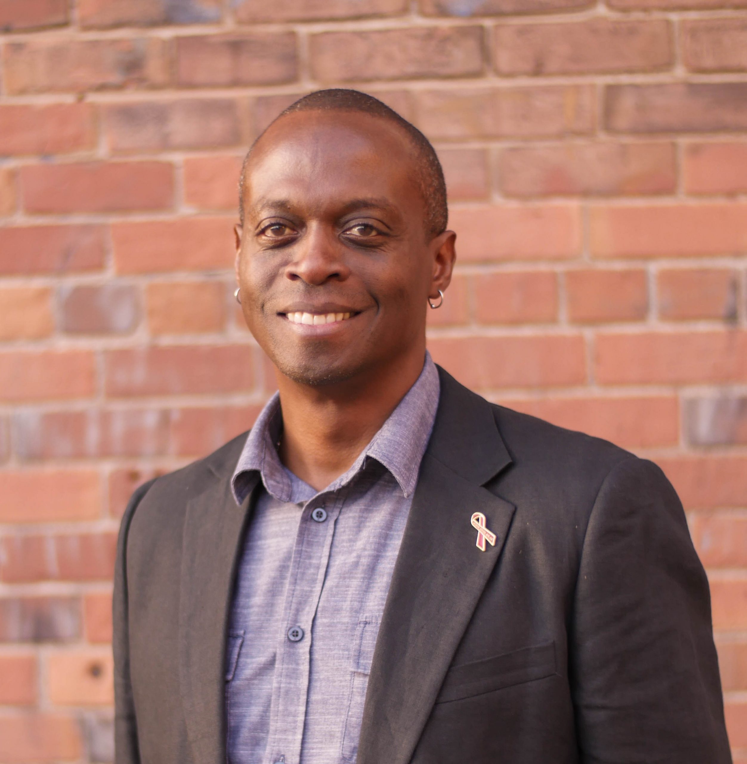 Keith Cunningham standing in front of a brick wall.