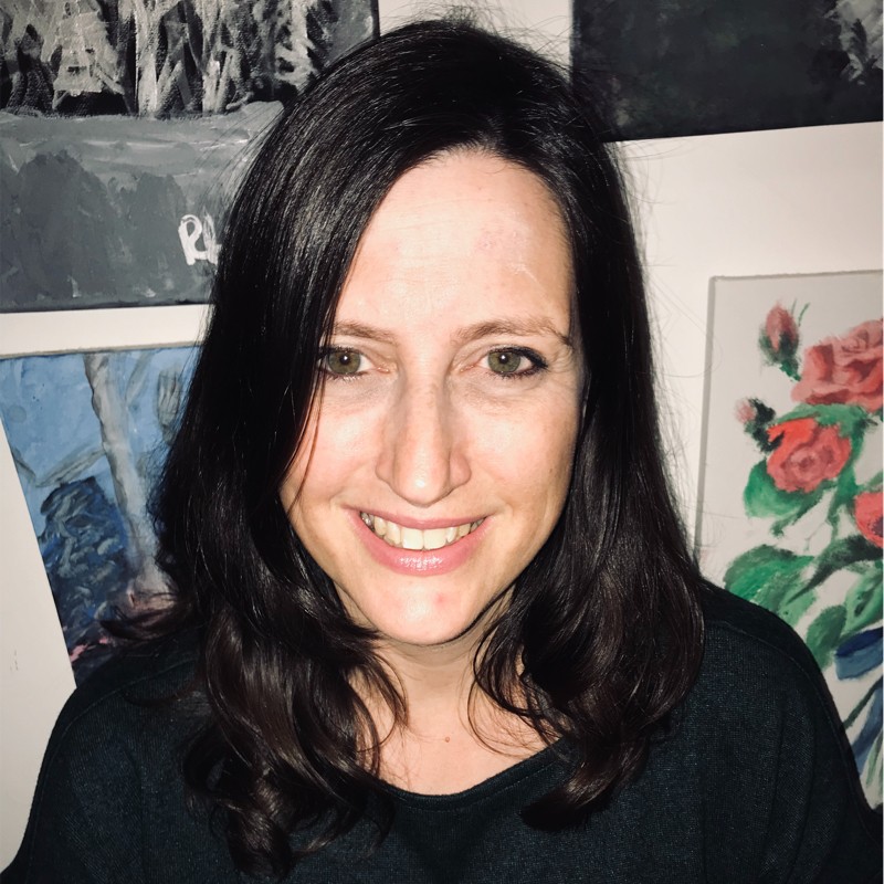 Amy Wilson with artwork on a wall in the background.