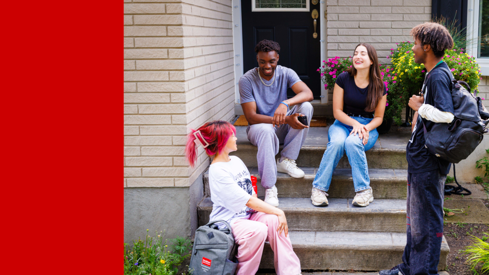 Four students sitting and standing around a front porch. They are speaking and laughing. 