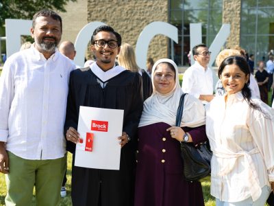 A family posses for a photo with their graduating student
