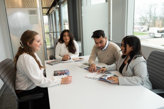A group of Students talking around a boardroom table