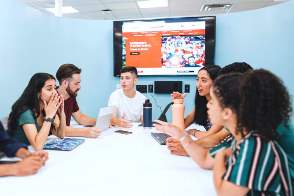 A group of Students talking around a boardroom table