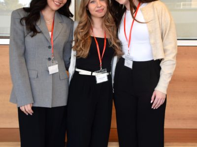 Three students in professional attire pose for a photo.