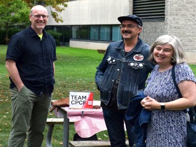 3 professors stand in front of a table labelled 