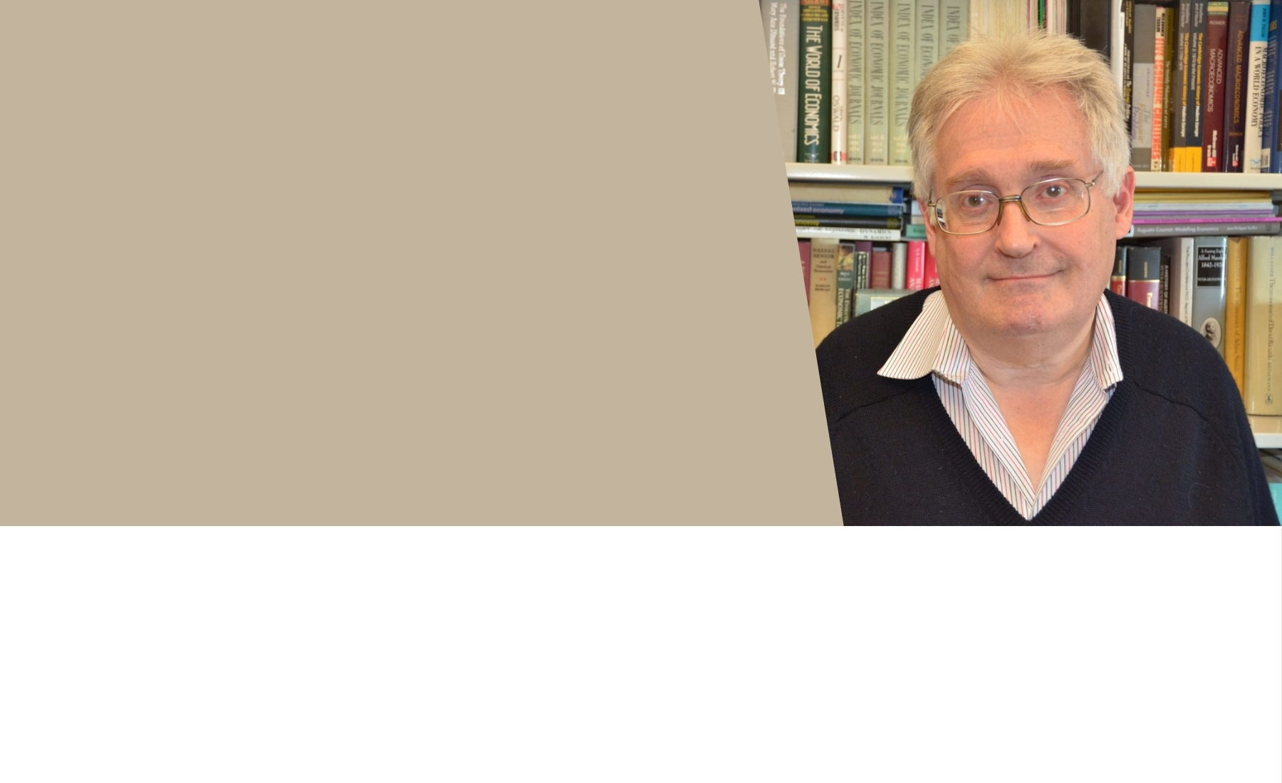Brock University Professor of Economics Robert Dimand standing in front of bookshelves. 
