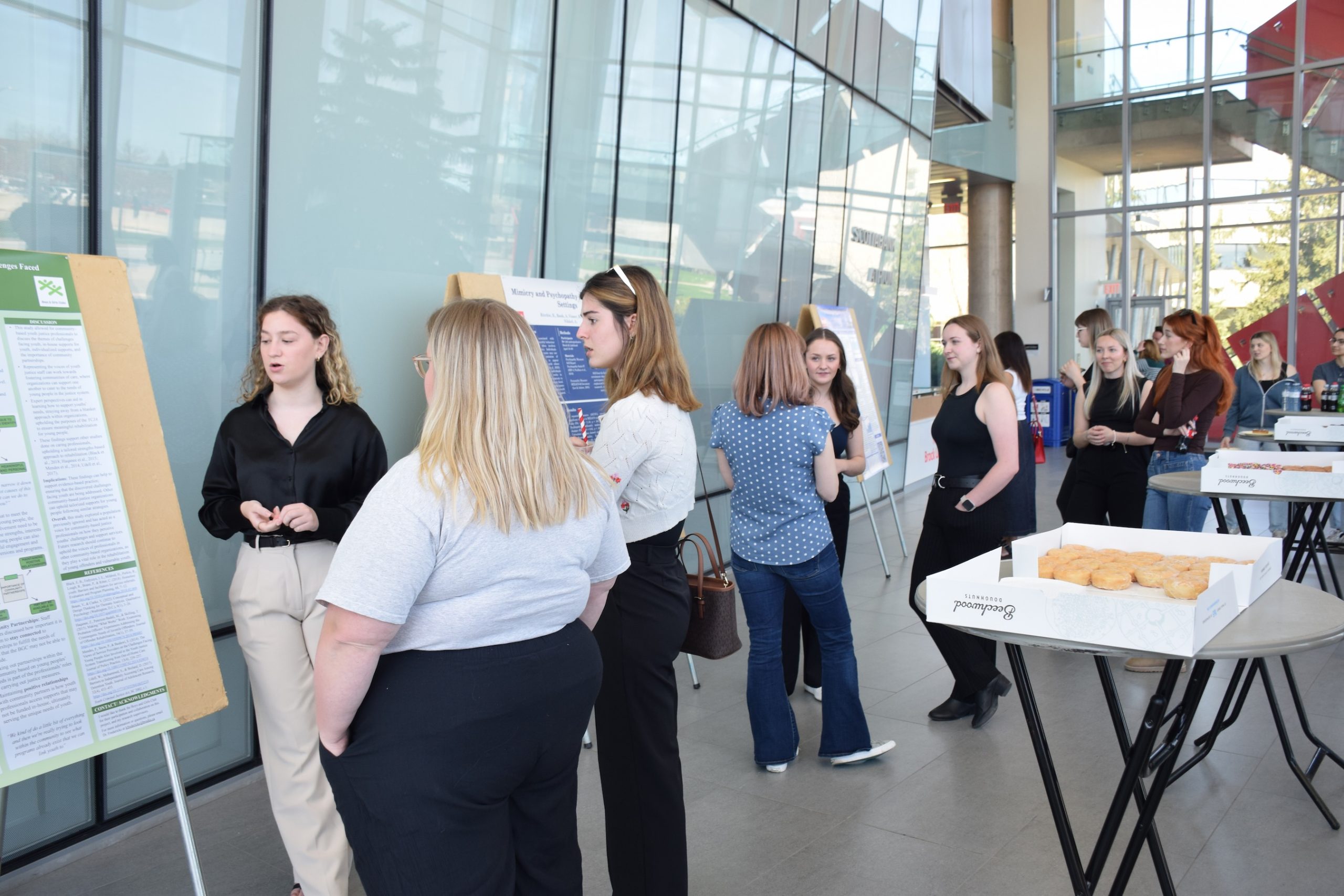 A small group of people conversing in front of research posters.
