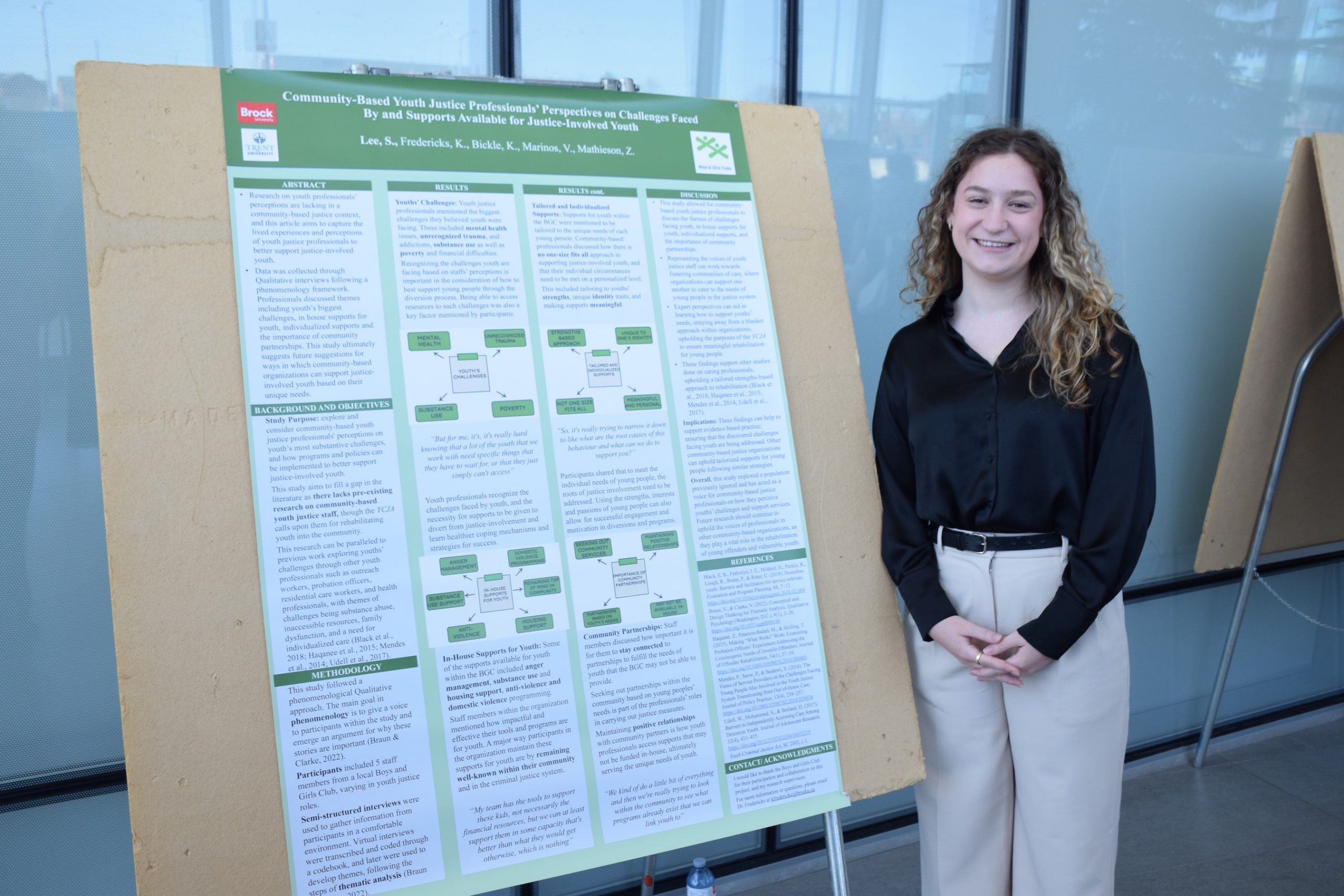 Student standing beside a research poster.