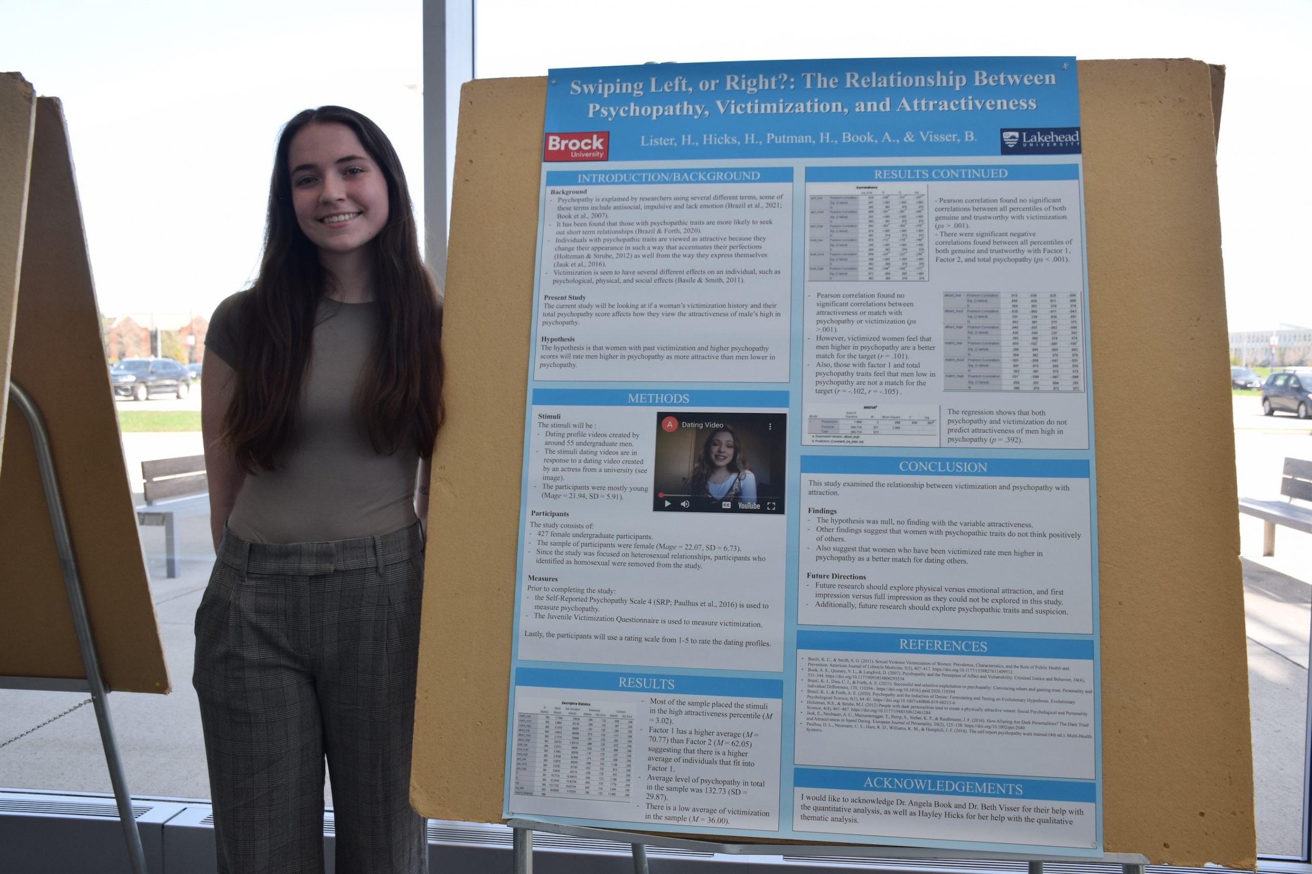 Student standing beside a research poster.