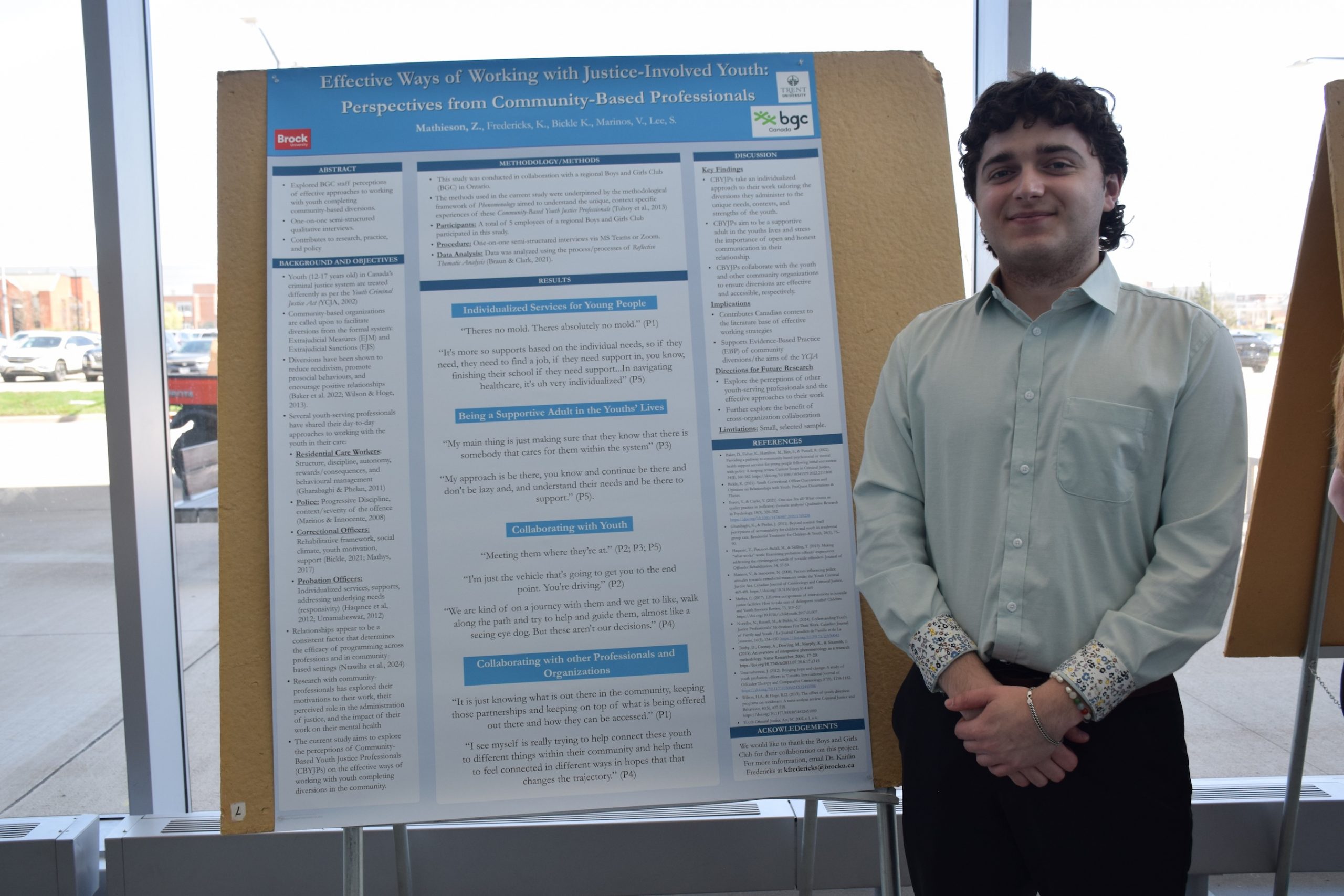 Student standing beside a research poster.
