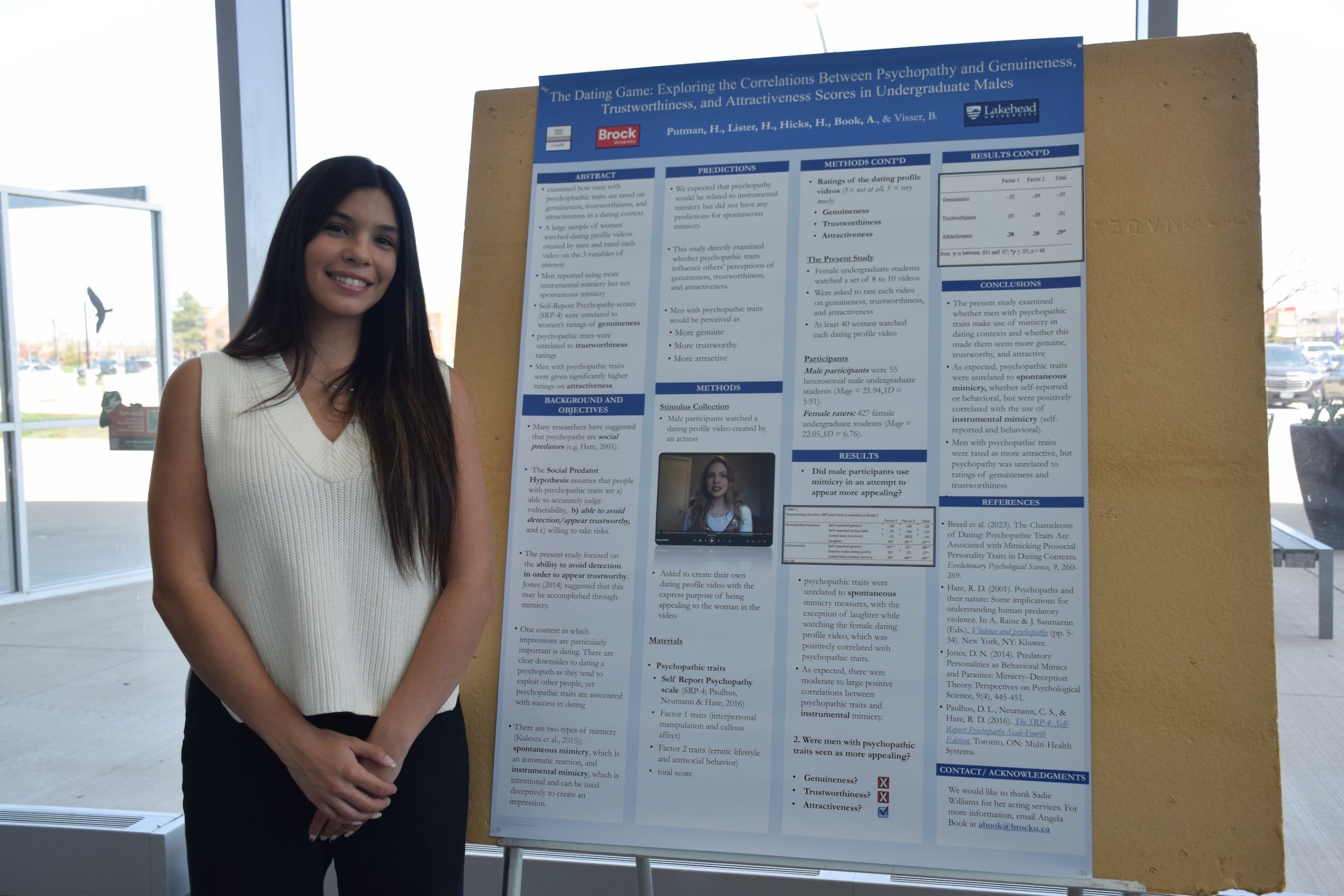 Student standing beside a research poster.