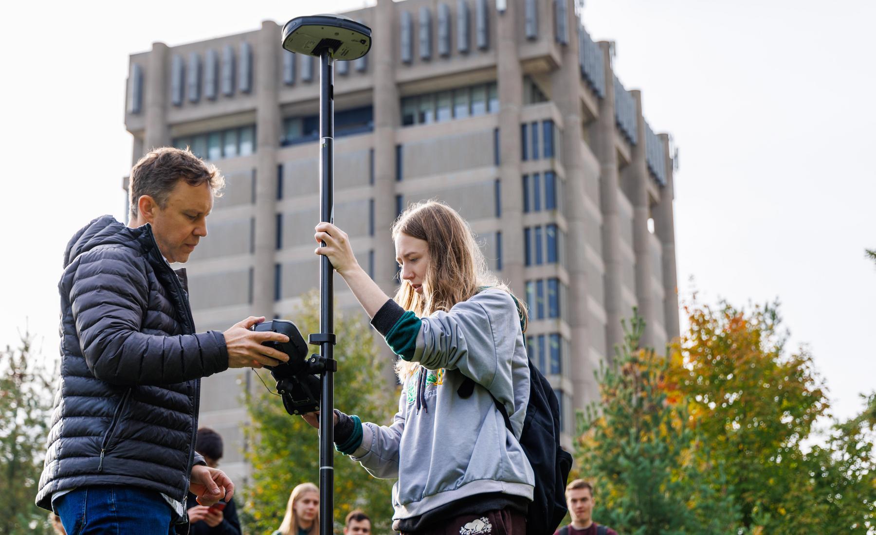 Kevin Turner and students discuss the use of 3D survey and digital mapping tools behind the Schmon Tower. 