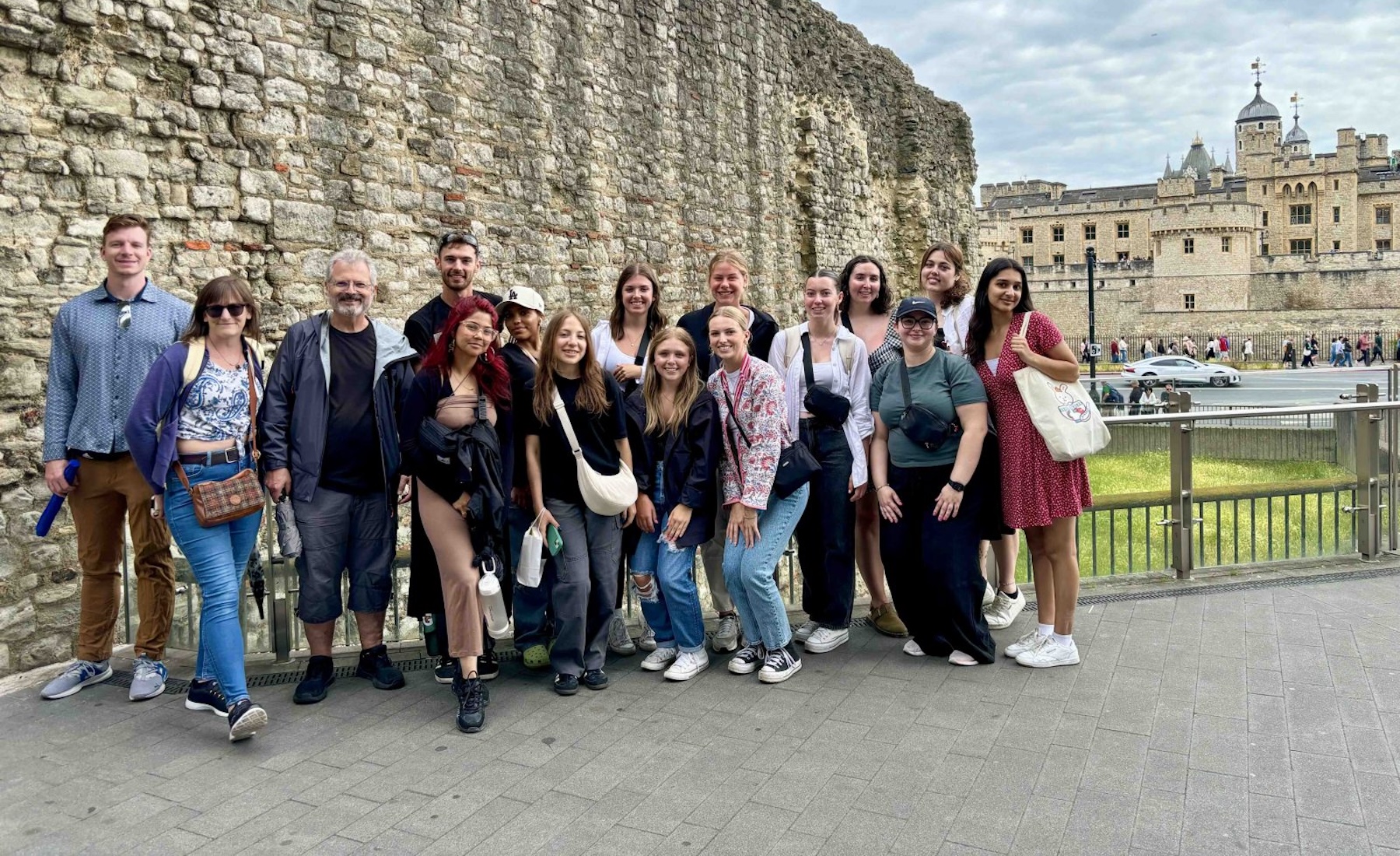 Students and Professor Phillip Mackintosh at a Roman wall with the Tower of London in the background. 