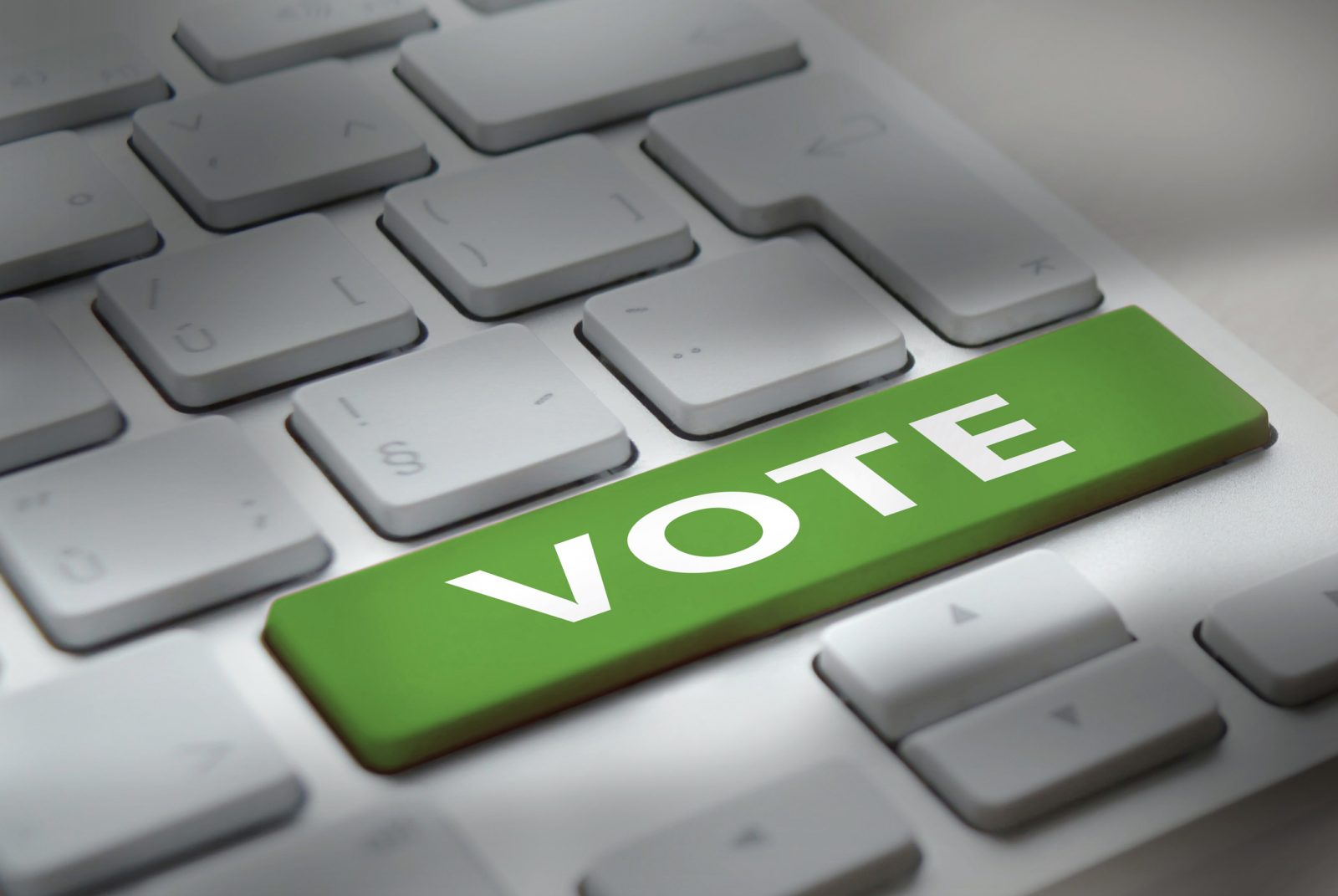 closeup of green keyboard key with white words vote on it