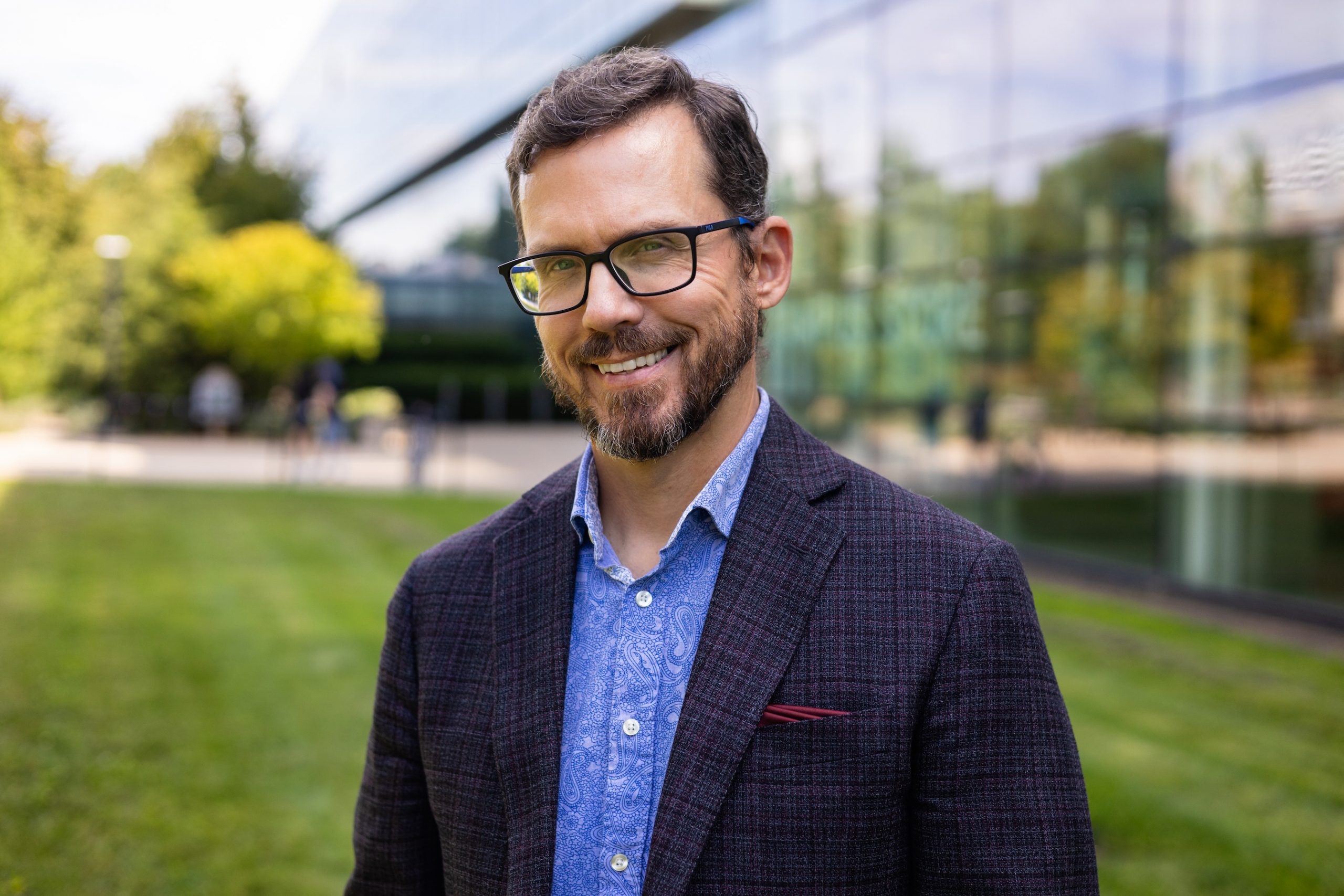 Stefan Dolgert outside on a sunny day in front of the Cairns' Family Health and Bioscience Research Complex on Brock University's main campus.