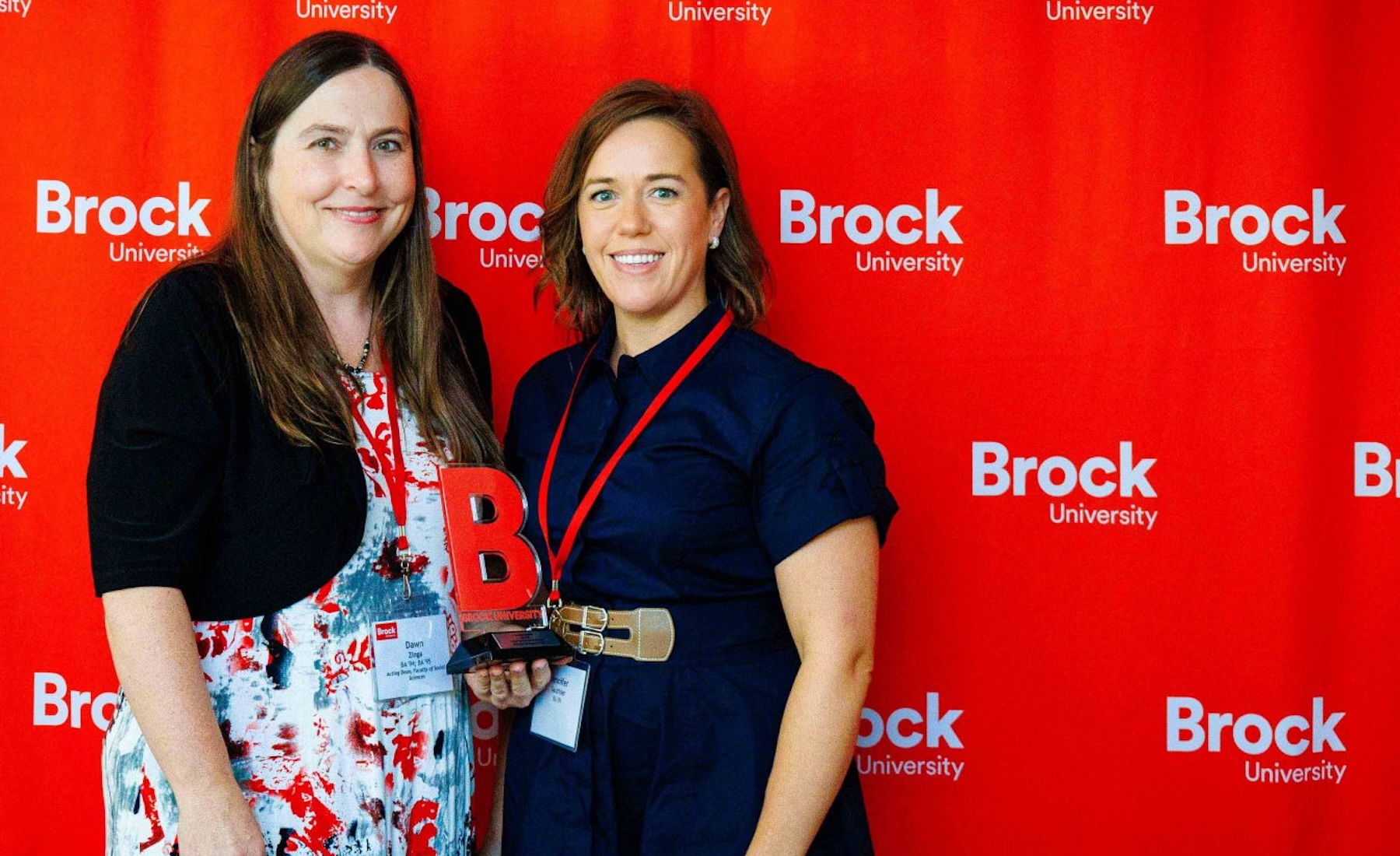 Dawn Zinga and Jennifer Gauthier against red Brock-branded screen. 