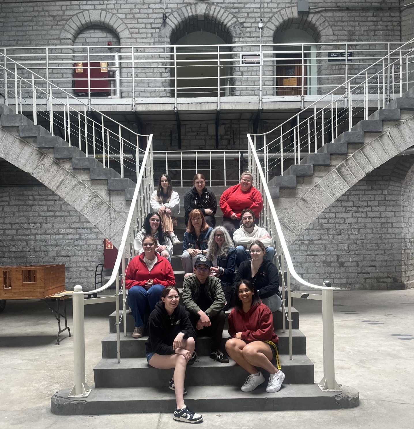FPAC-fieldcourse A group of people sitting on a staircase in a prison.