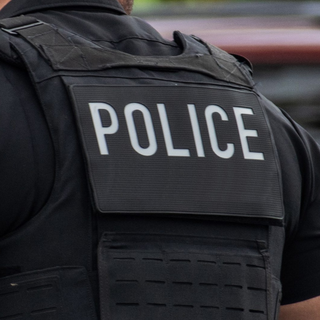 GettyImages-1460907609-copy-1600x1067 Close-up of the word police printed on the back of an officer's uniform.