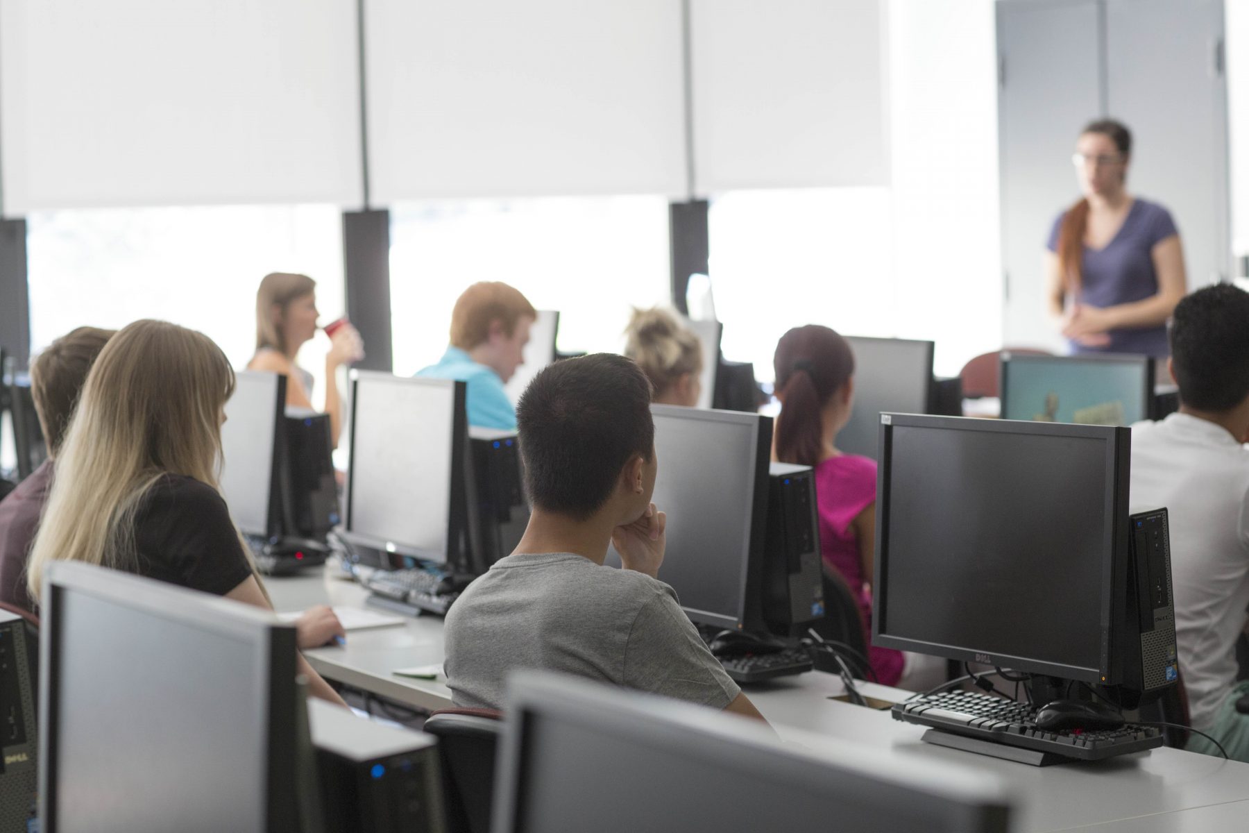 Students sitting at computers facing an instructor
