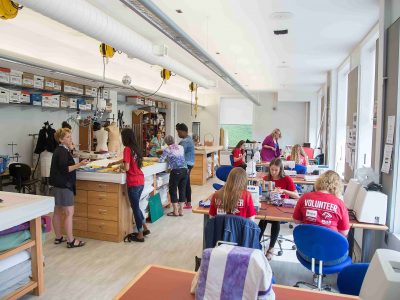 Numerous students at sewing machine at a Brock Cares project