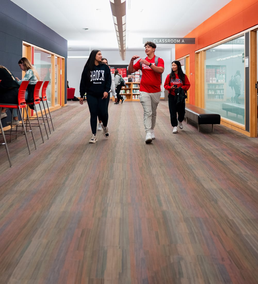 Four Brock students walk through the James A. Gibson Library. 