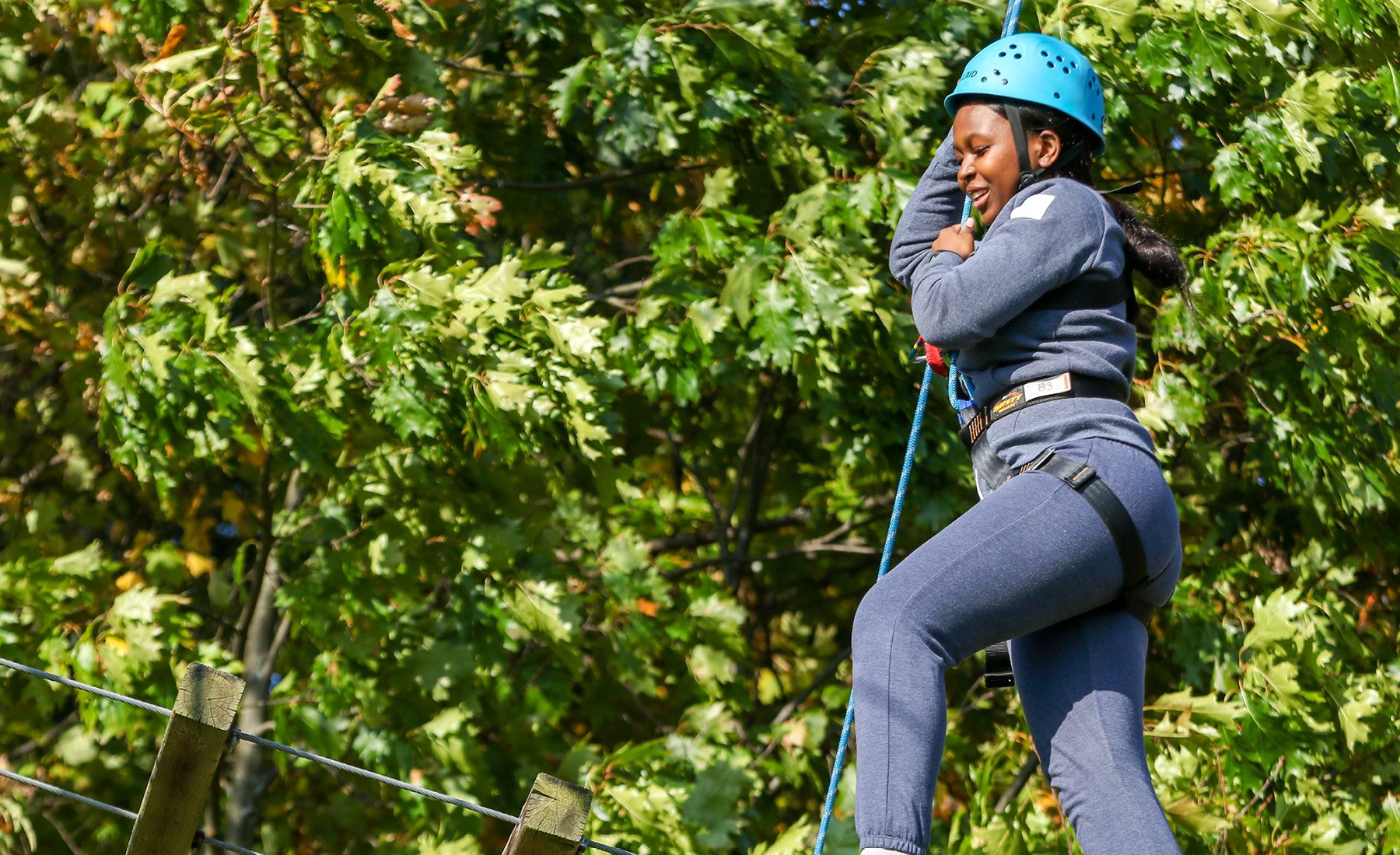 young female in safety gear rope climbing 