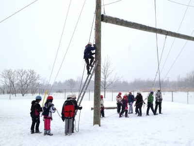 Group of people participating in the outdoor ropes course in the winter